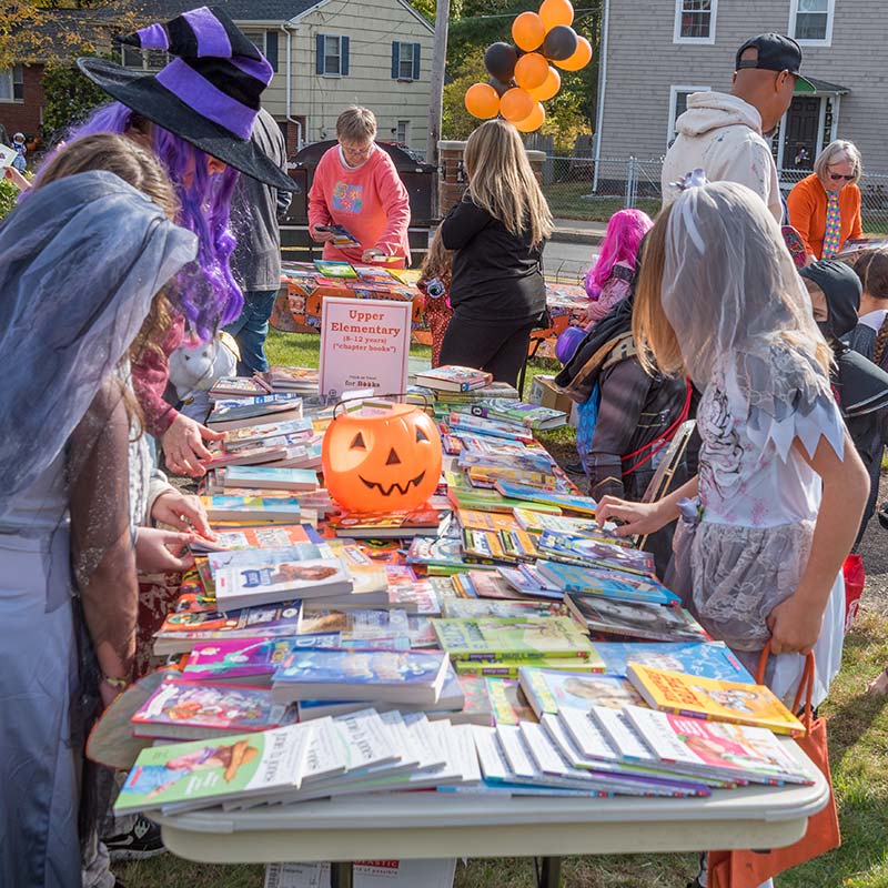 Children browse tables of free books outside
