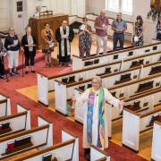 Pastor Shelly delivers Benedition from with a circle of congregants.