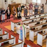 Pastor Shelly delivers Benedition from with a circle of congregants.