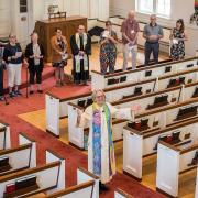 Pastor Shelly delivers Benedition from with a circle of congregants.
